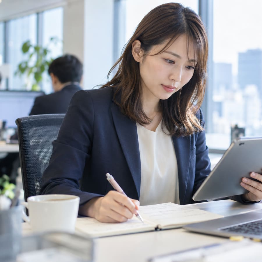 タブレットを見ながらキャリアについてメモを取る会計士